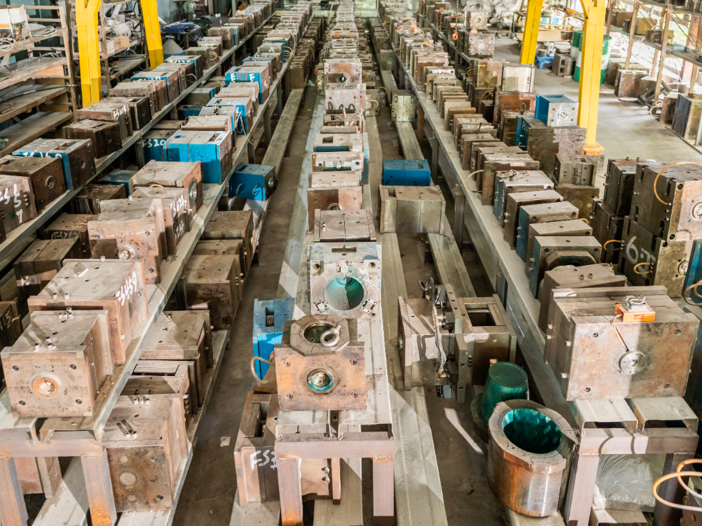 A wide shot of rows of finished metal molds on shelves in a factory.